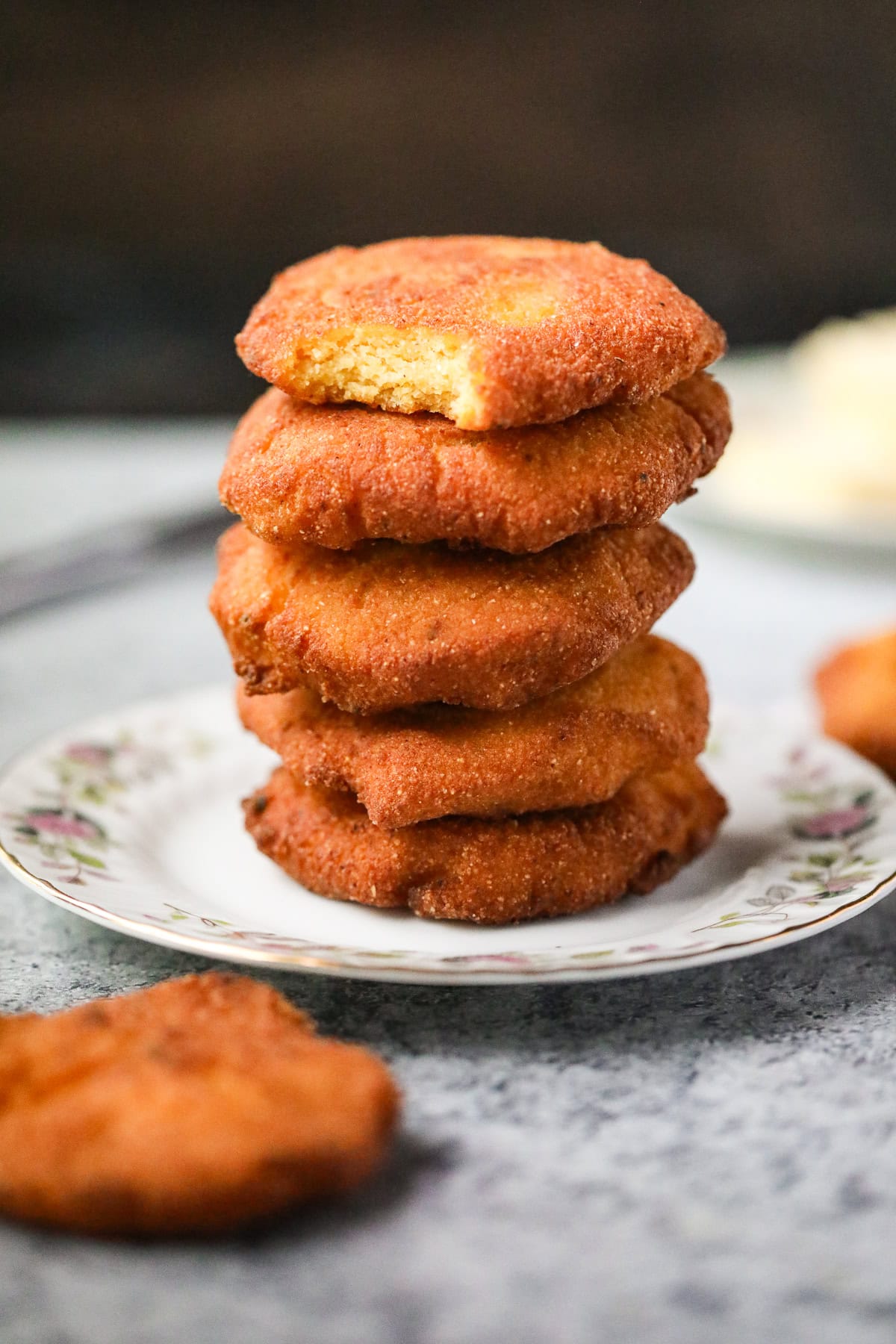 Hey stack of hot water cornbread patties on a plate.