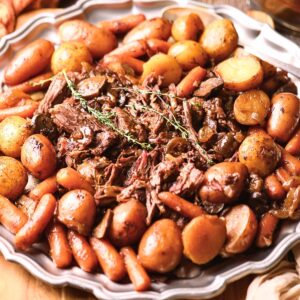 Ultimate Dutch oven pot roast with vegetables on a serving platter.