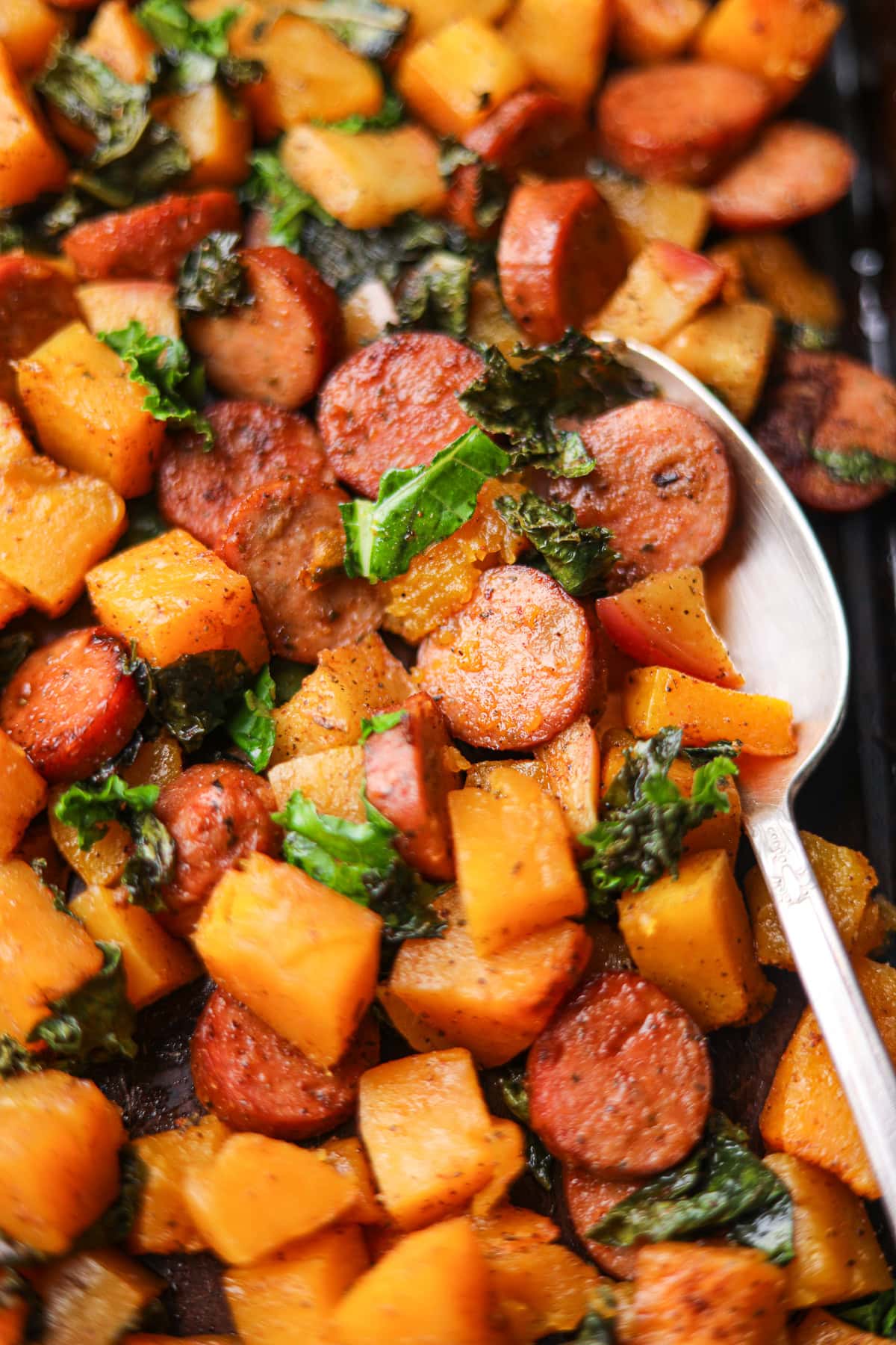Chicken sausage and butternut squash sheet pan meal sitting on a table top.