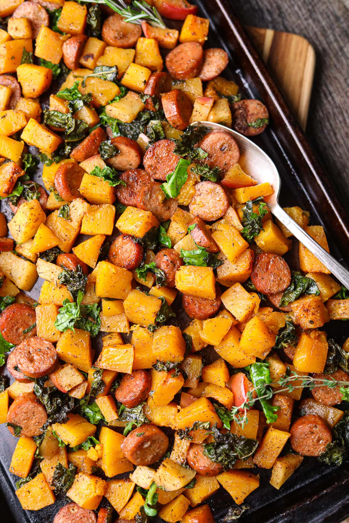 Chicken sausage and butternut squash sheet pan meal sitting on a table top.