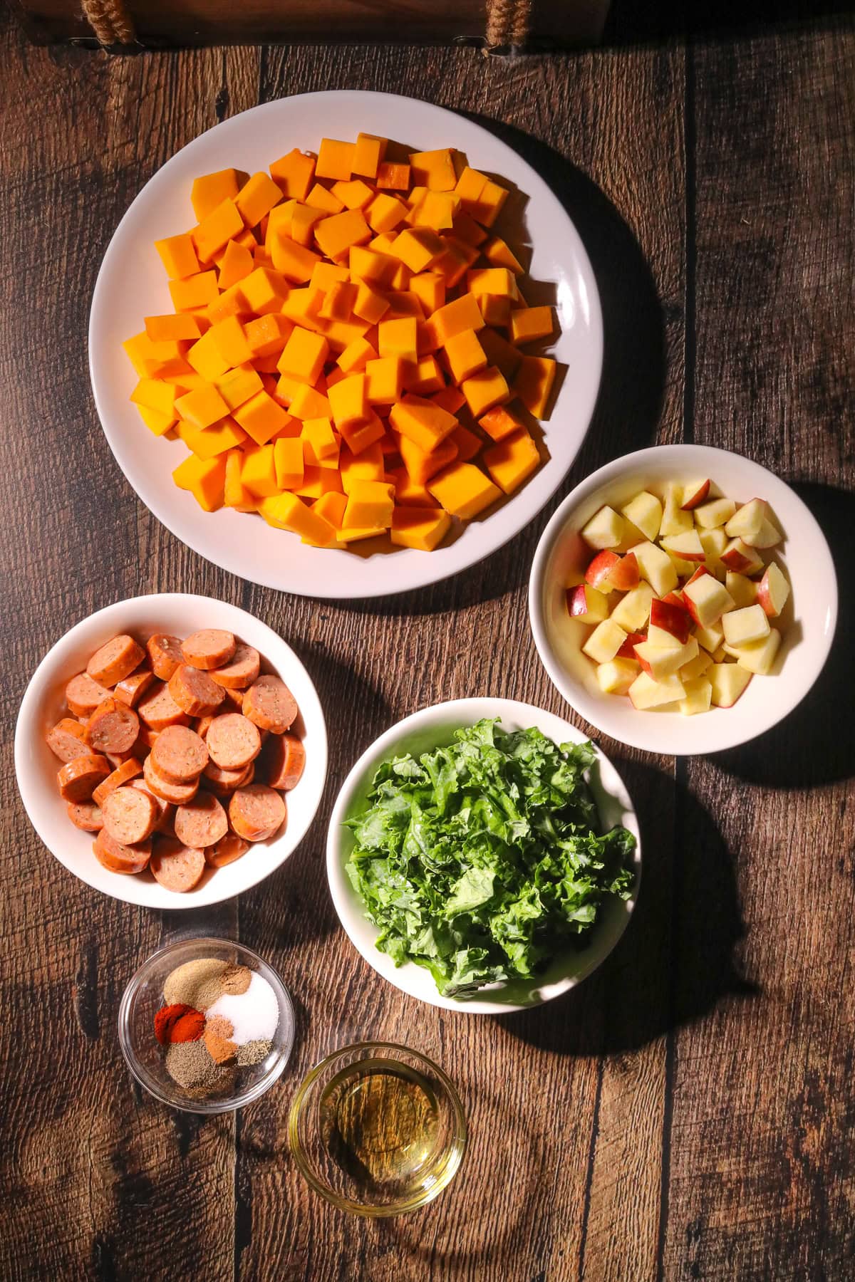 Ingredients for making chicken sausage and butternut squash, sheet pan meal sitting on a table top.
