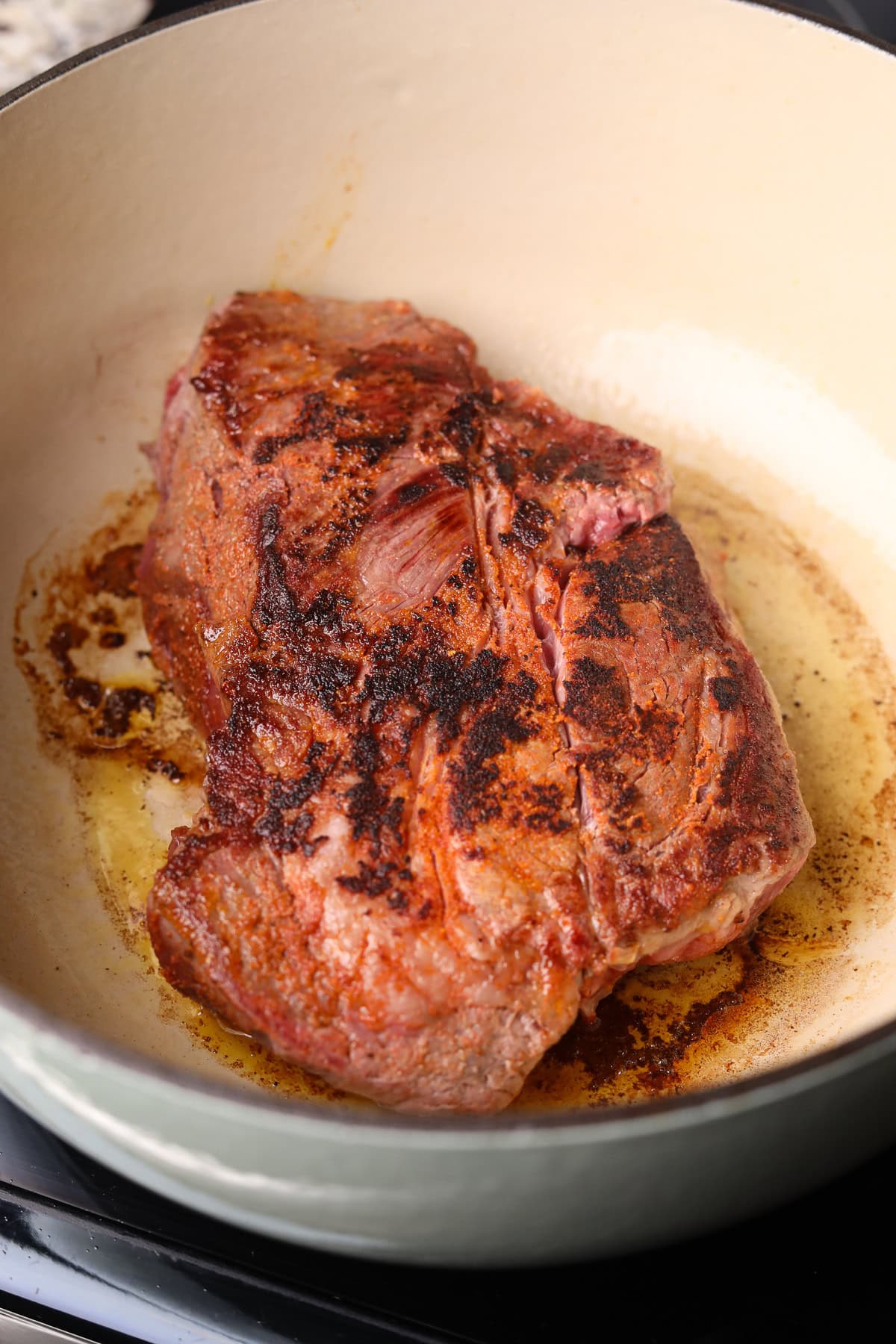 Season chuck roast, searing in a Dutch oven.