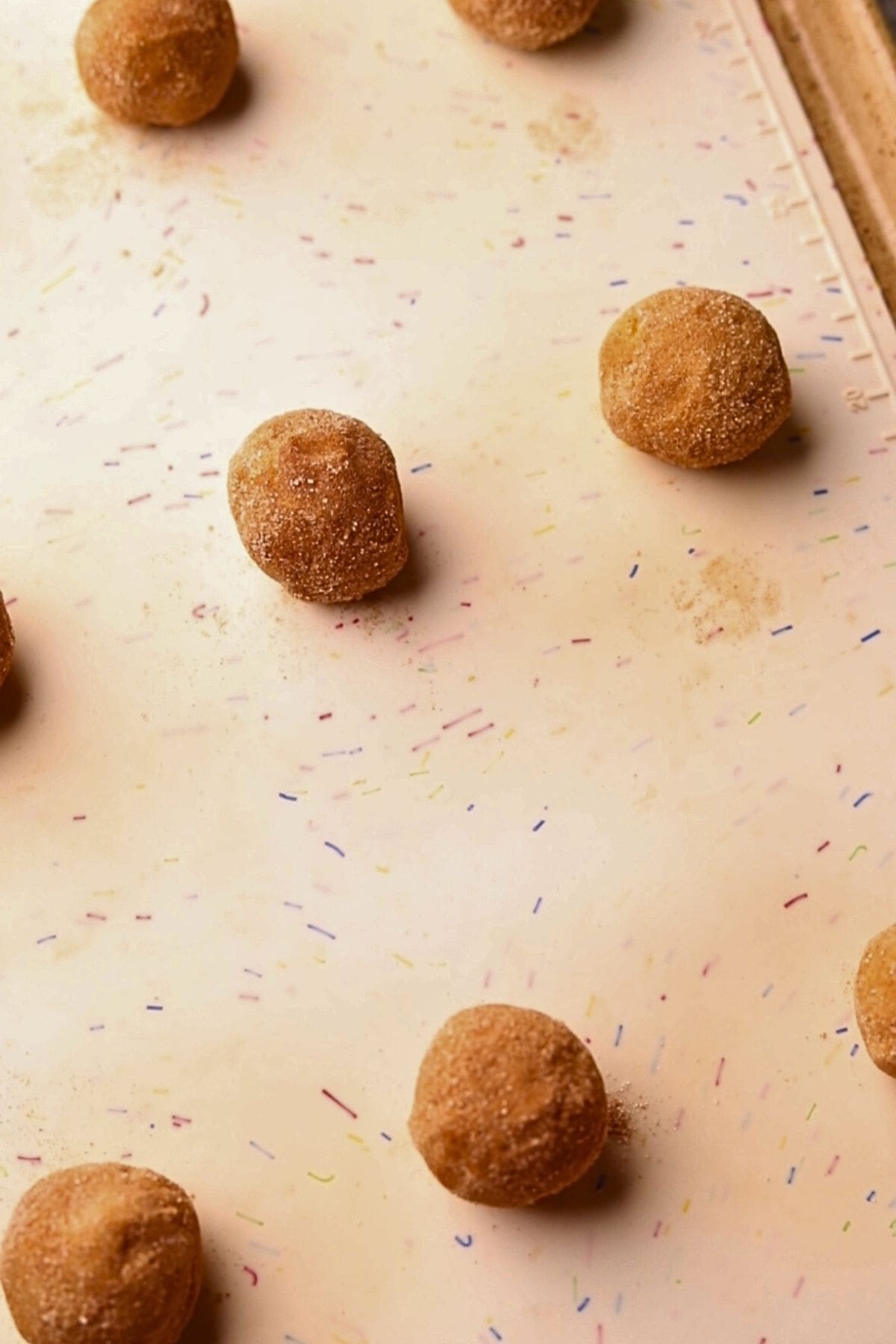 Apple butter, molasses, snickerdoodle dough balls on a baking sheet.