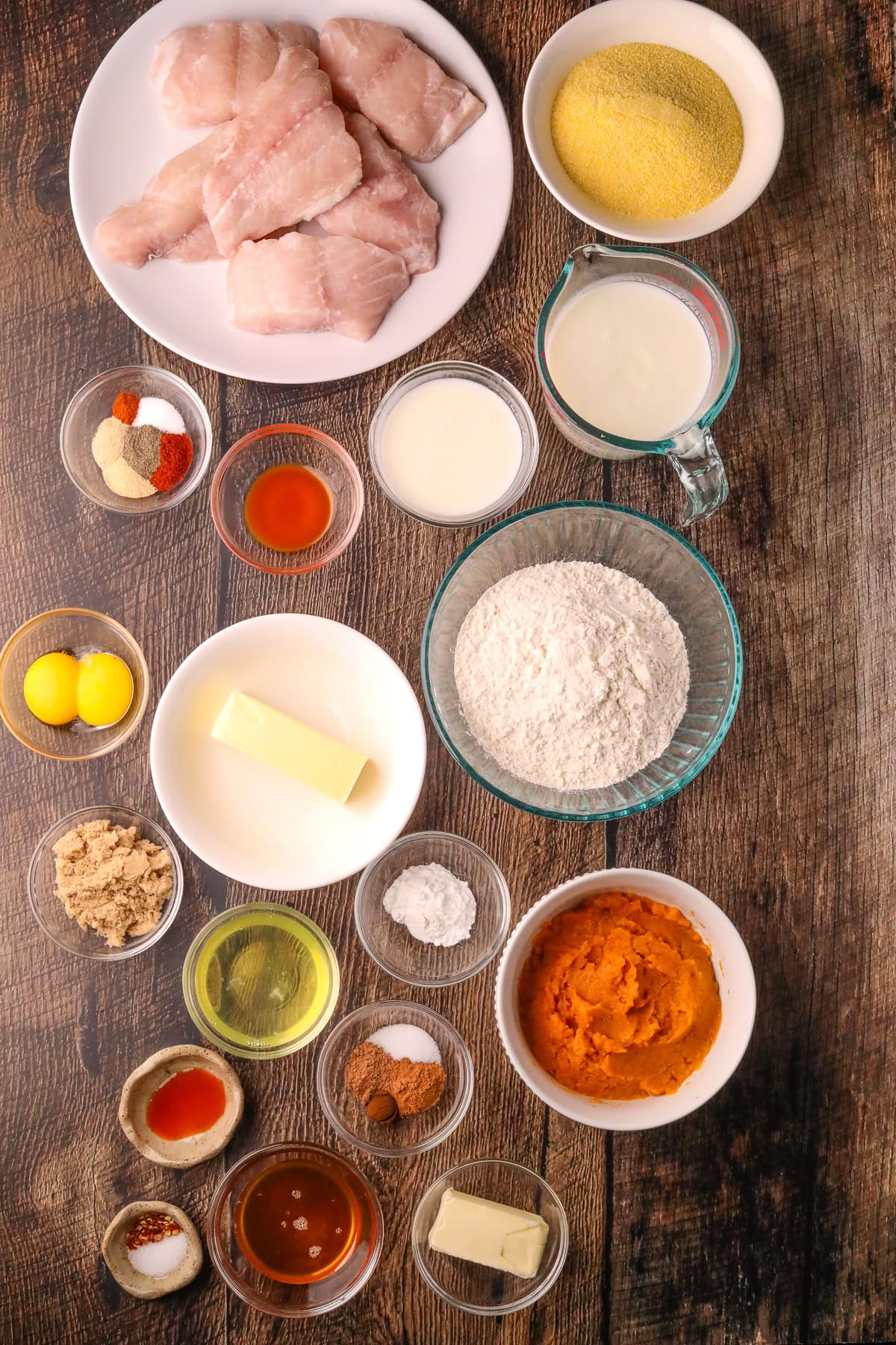 Ingredients for making sweet potato waffles, with fried catfish and spicy honey better arranged on a table top.