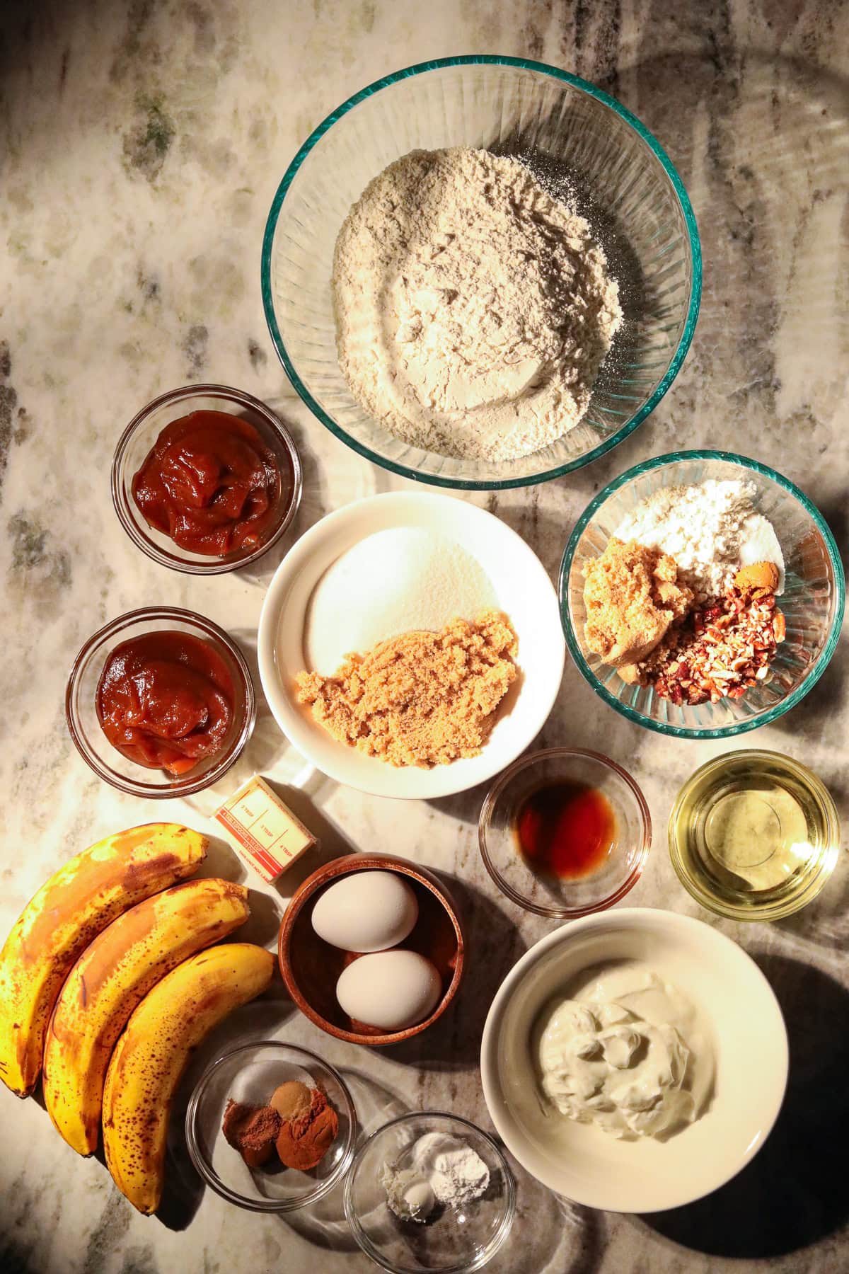 Apple butter, banana bread with pecan streusel ingredients, arranged on a table top.