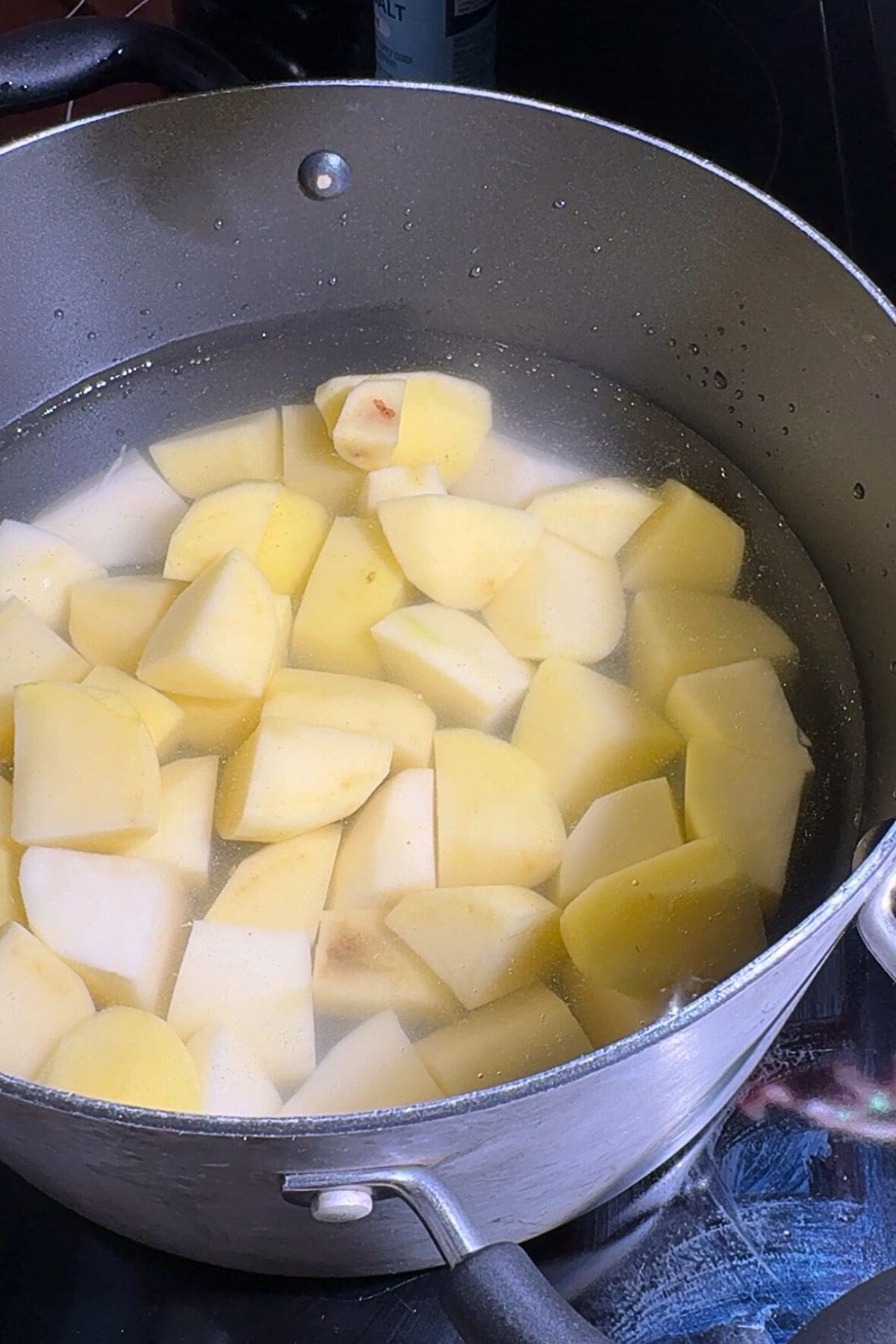 Cubed potatoes boiling in a pot.