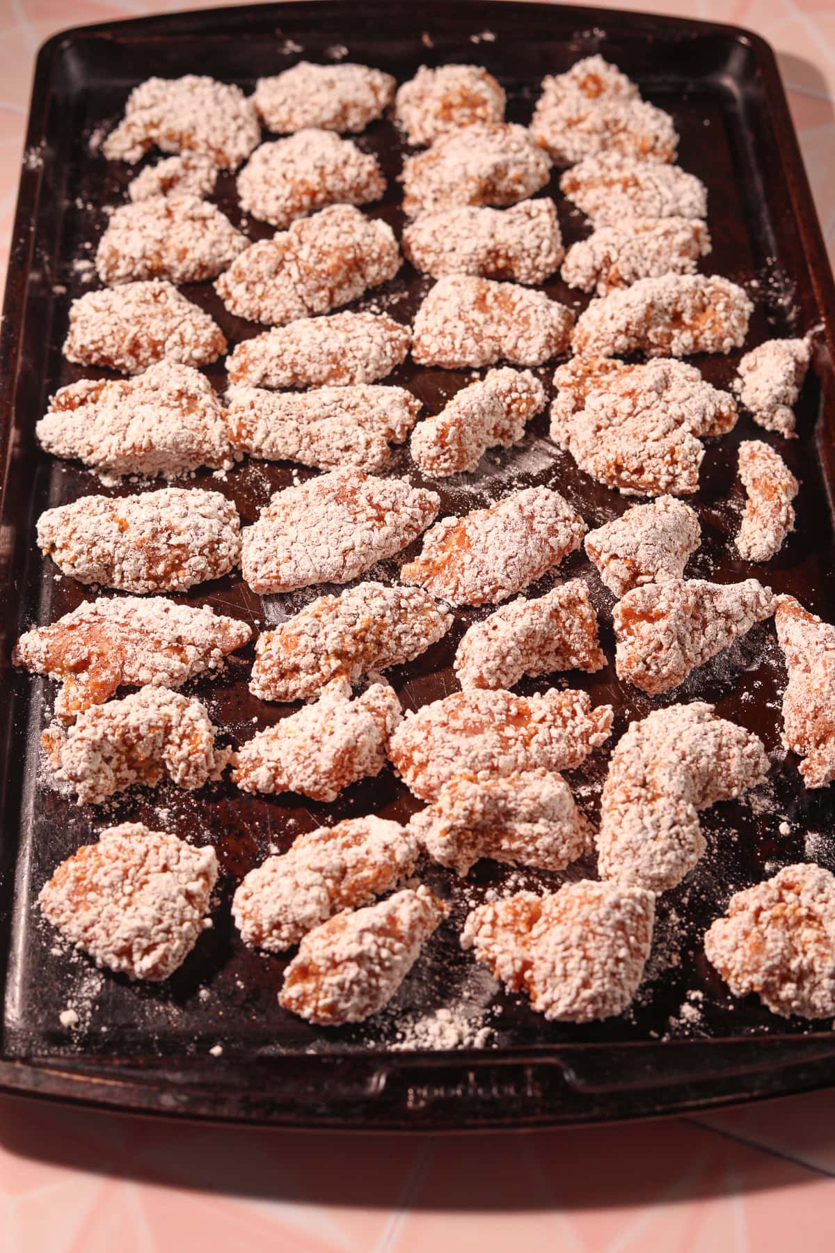 Breaded chicken chunks resting on a pan.