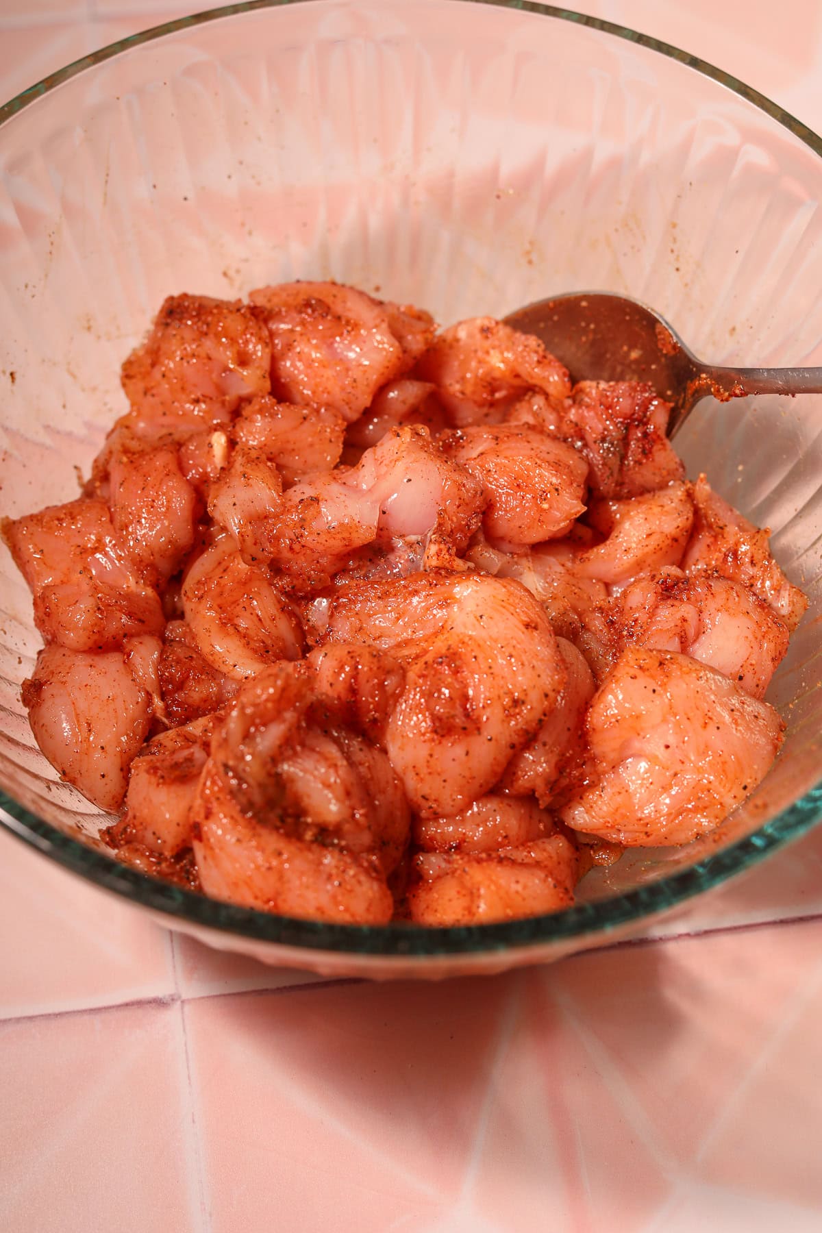 Seasoned raw chicken chunks in a bowl for hot honey. Garlic chicken bites.
