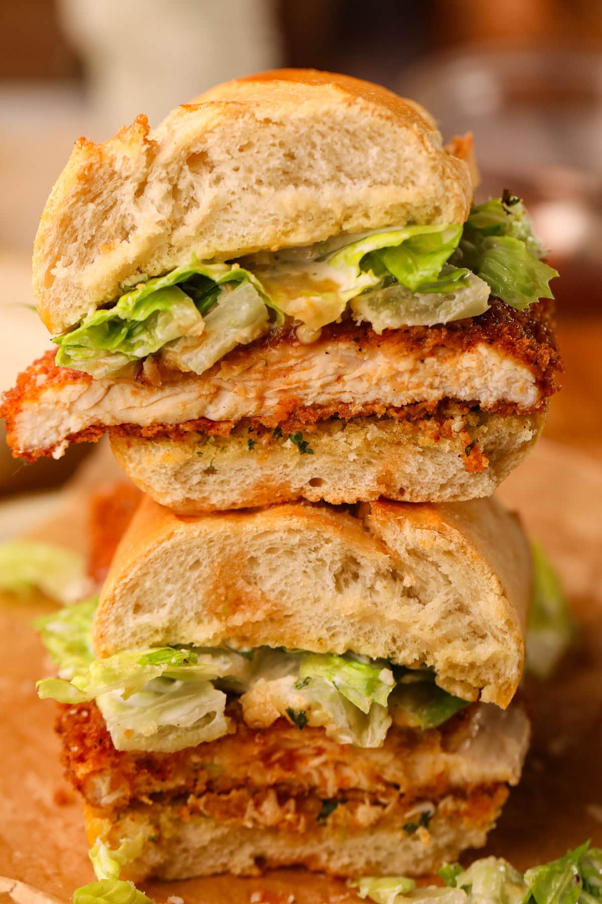 Spicy chicken, Caesar sandwich, sliced in half on a plate.