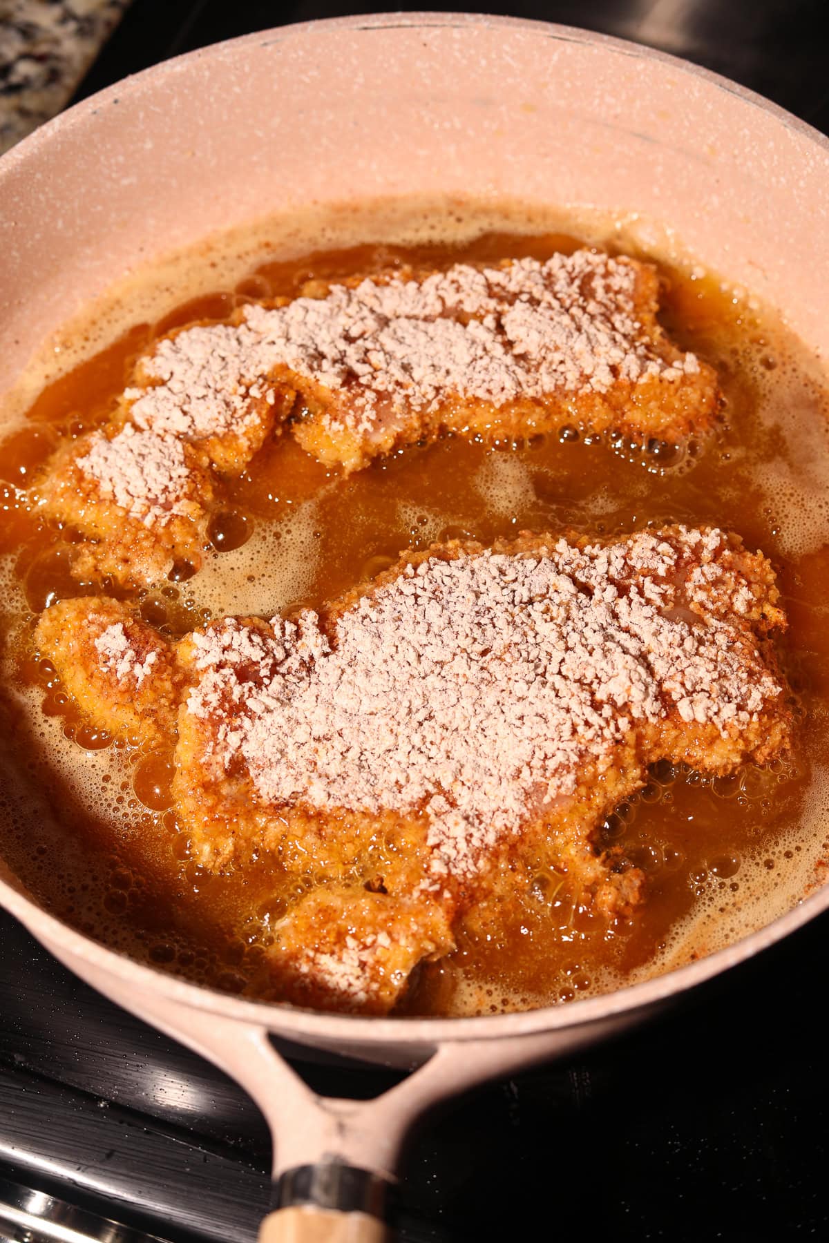 Chicken breast frying in hot oil.