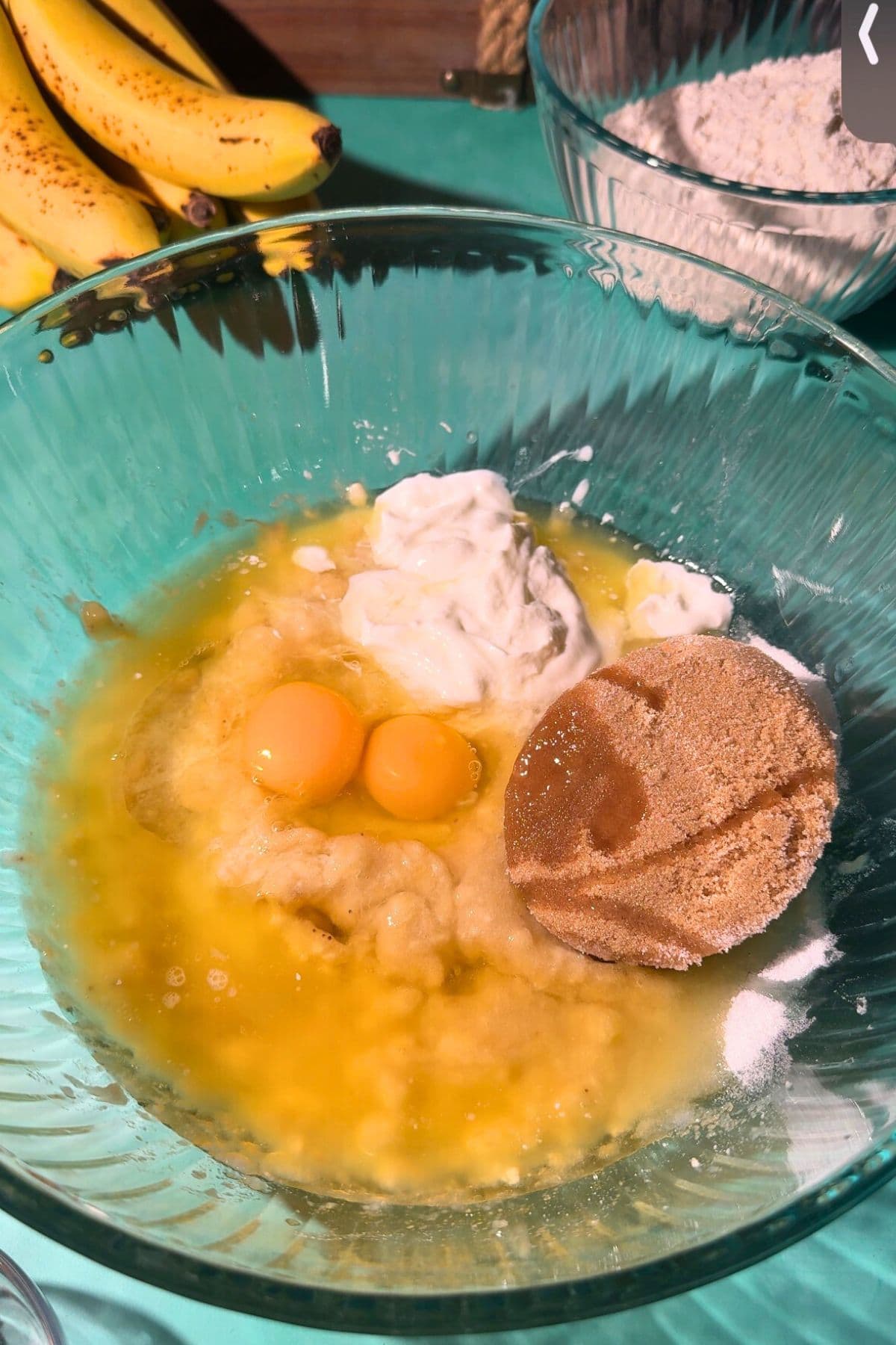 Wet ingredients for cinnamon swirl banana muffins in a large mixing bowl