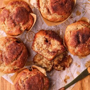Cinnamon swirl banana muffins on a wooden board.