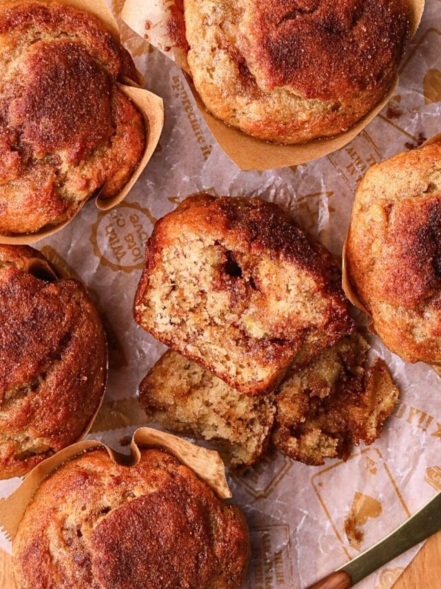 Cinnamon swirl banana muffins on a wooden board.