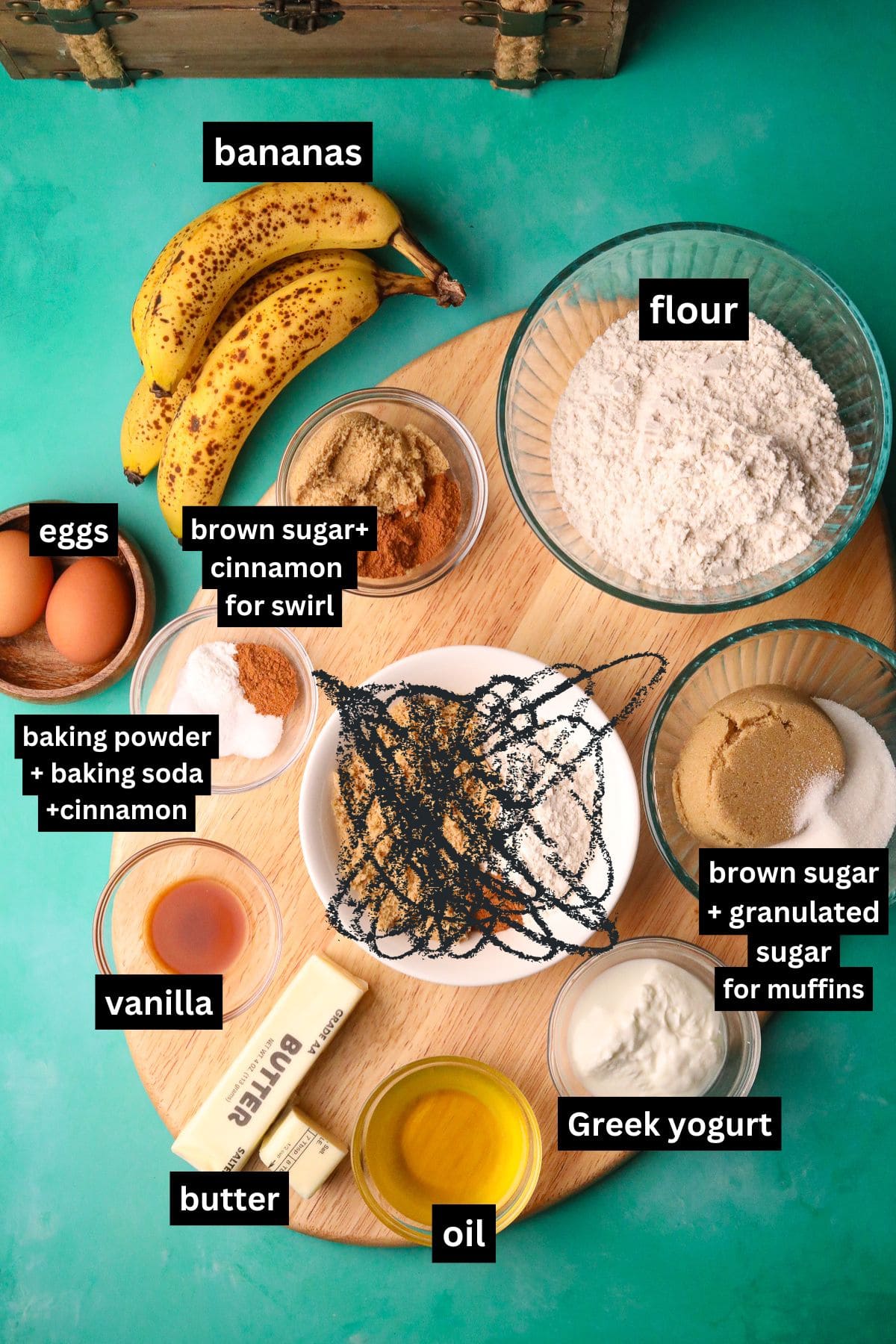 Cinnamon swirl banana muffins, ingredients in bowls, arranged on a table top.