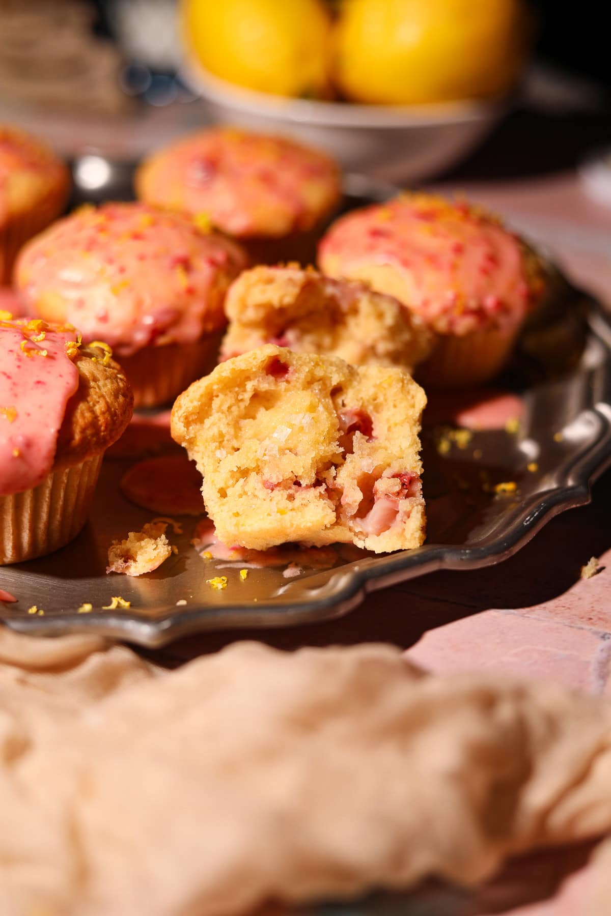 Strawberry lemonade, muffins on a platter with one sliced in half to show detail.