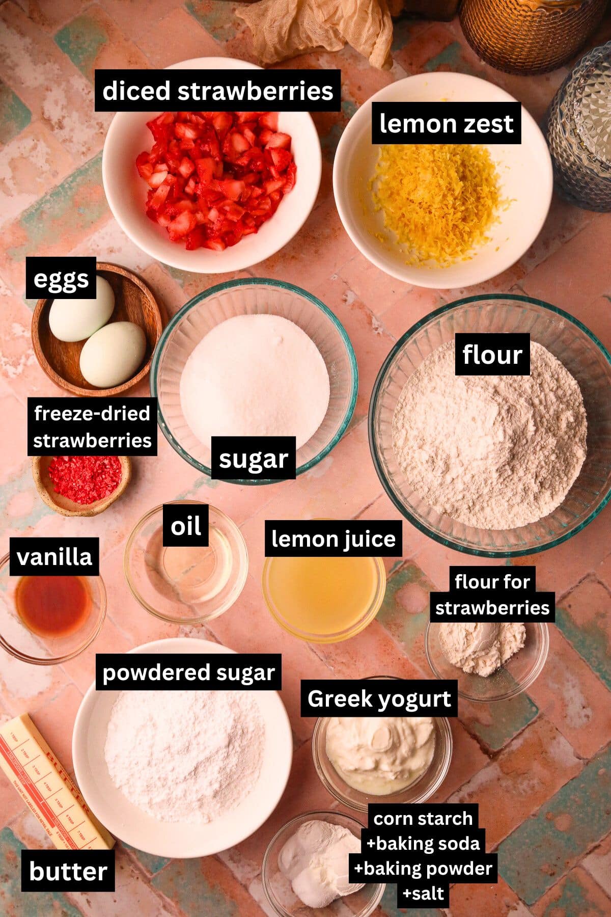 Strawberry lemonade muffin ingredients in bowls with text overlay arranged on a table top. 