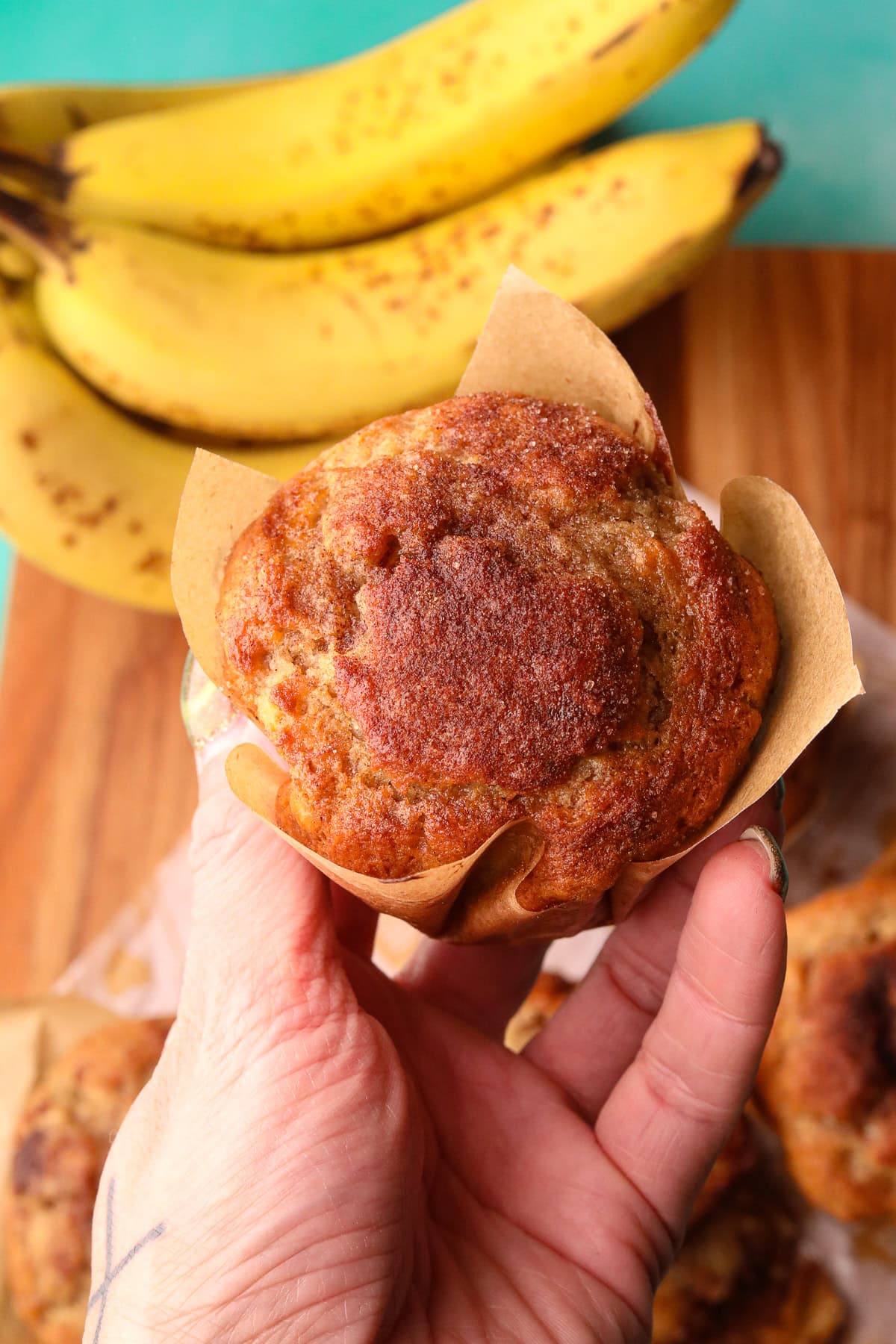 Cinnamon swirl banana muffin held in hand to show detail.