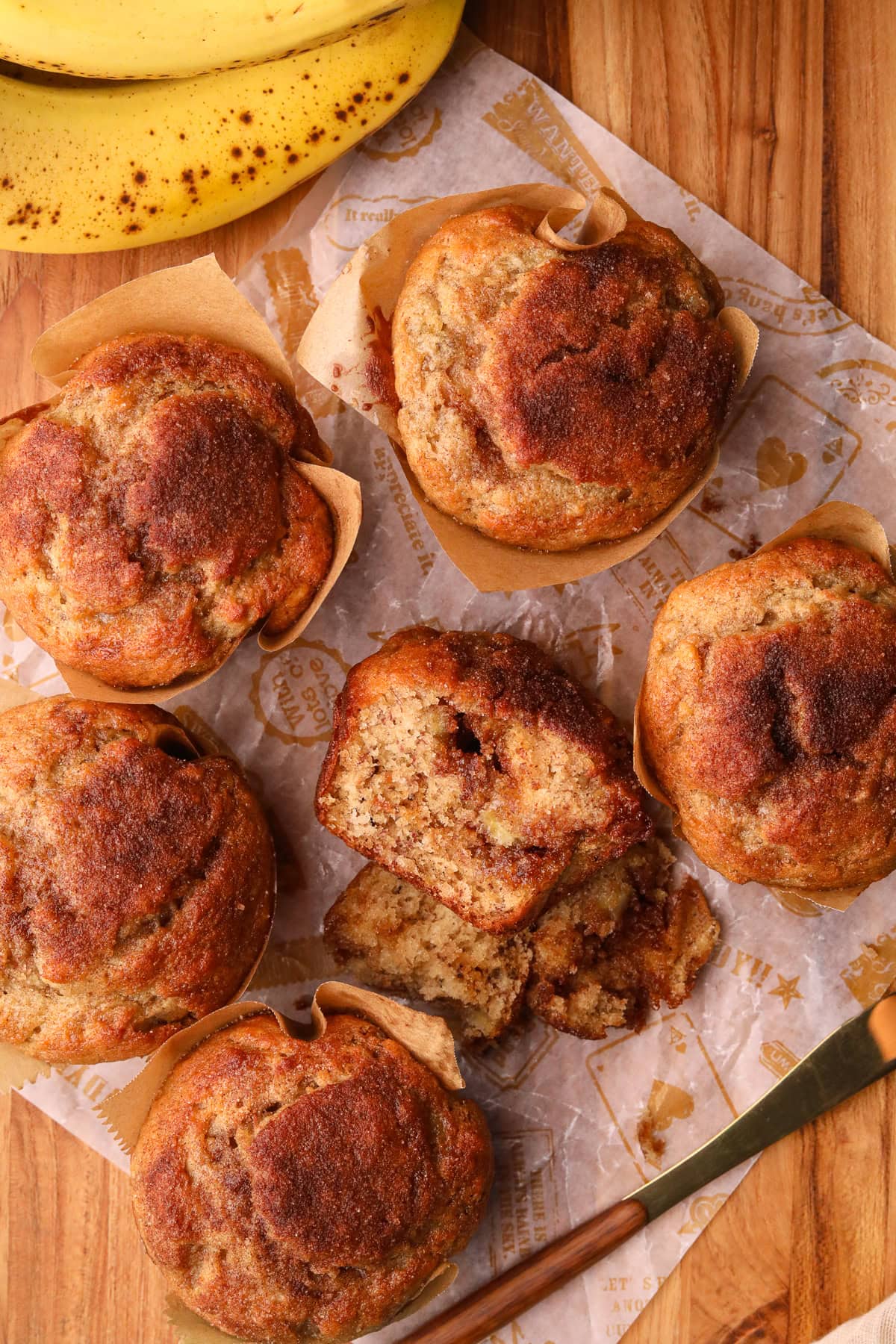 Cinnamon swirl banana muffins on a wooden board. 