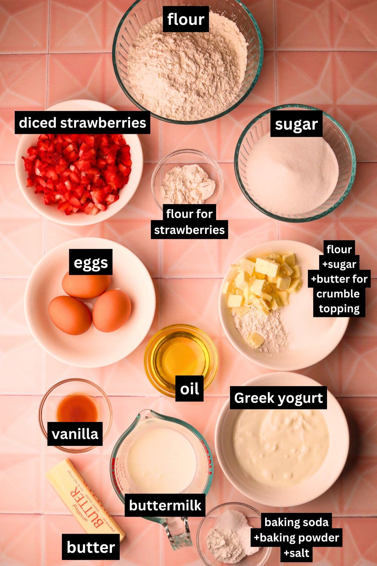 Strawberry shortcake muffin ingredients in bowls arranged on a table top.