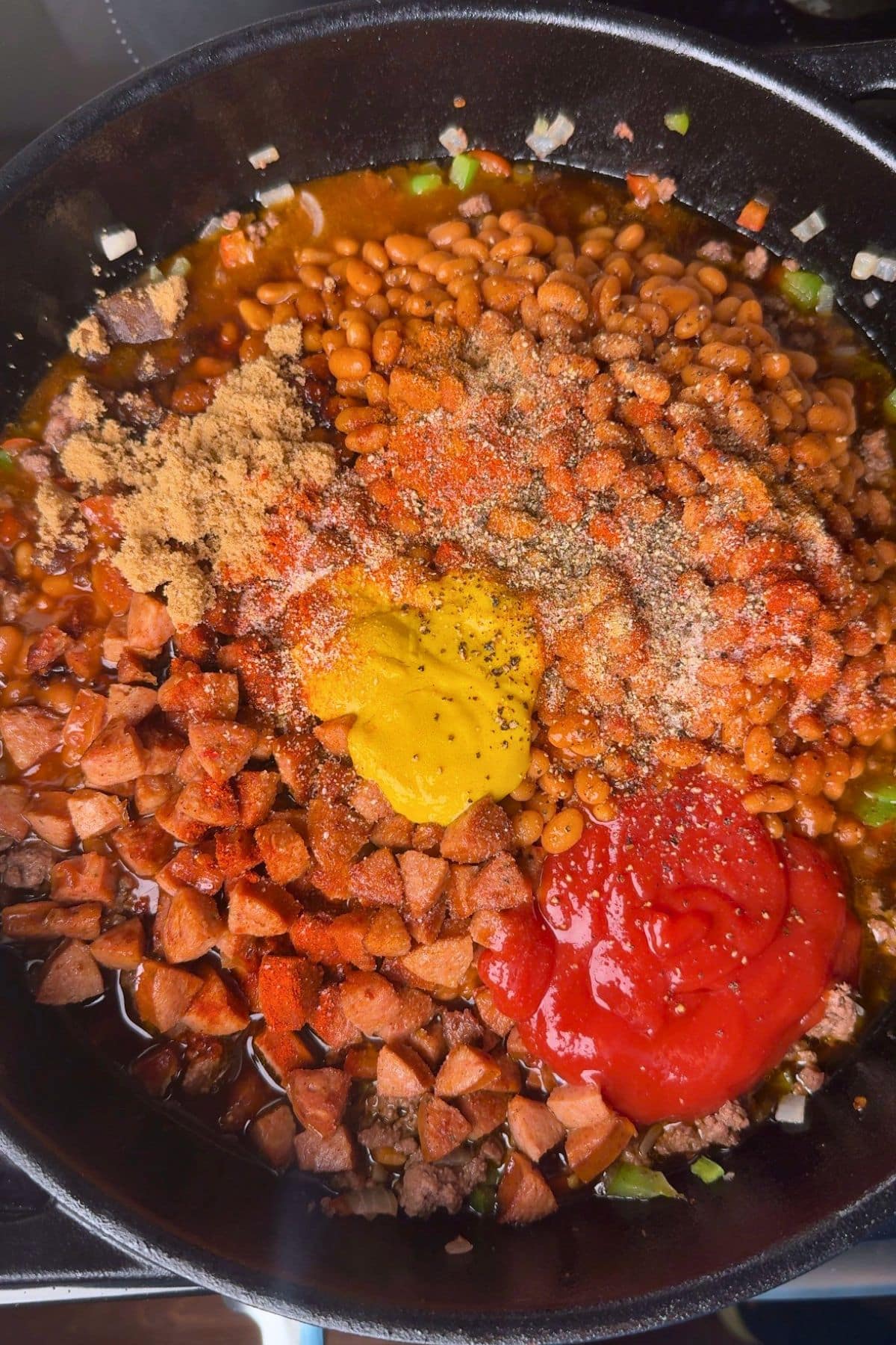 Barbecue baked bean ingredients in a pan before being mixed together.