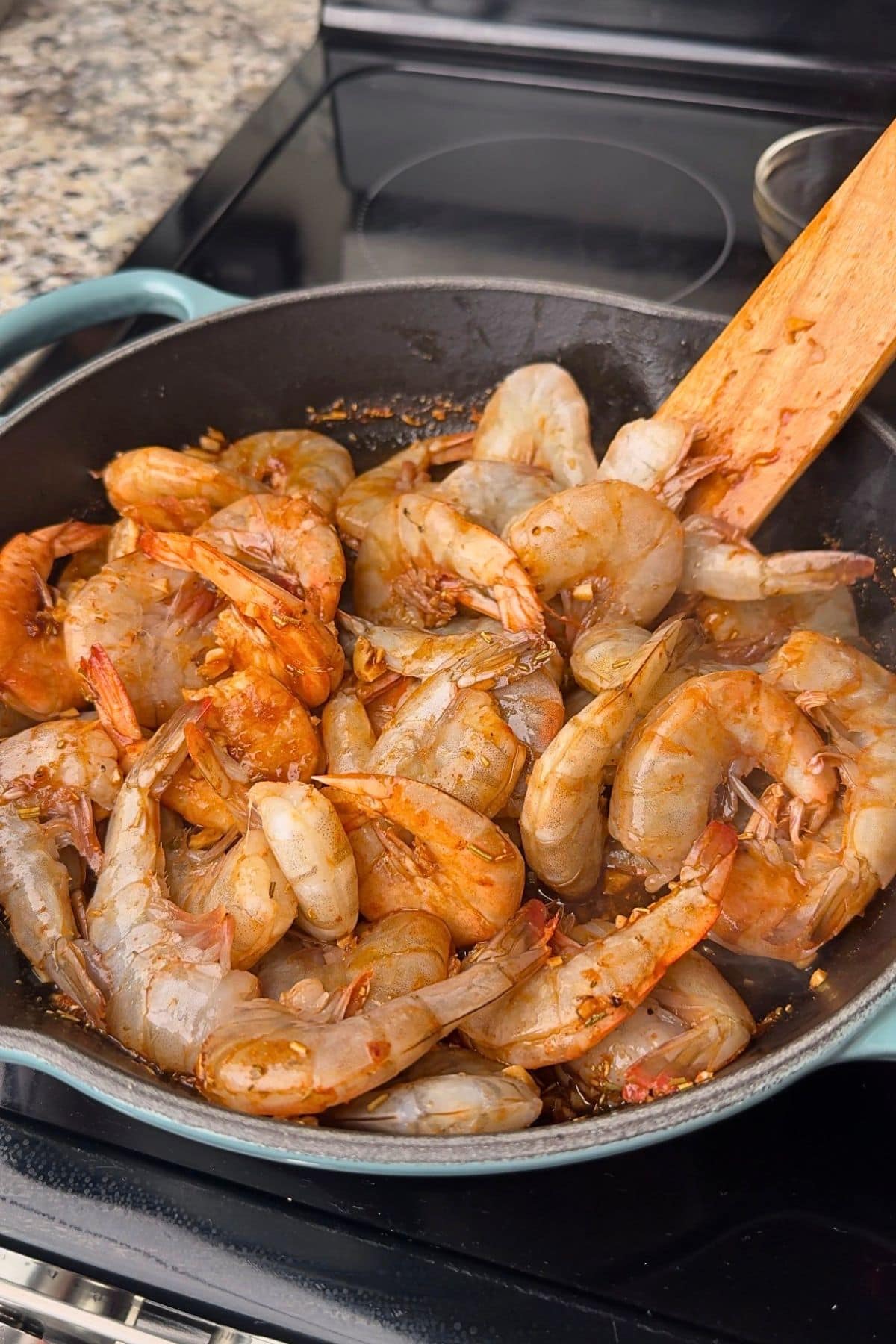 Shrimp in a pan cooking for New Orleans BBQ shrimp.
