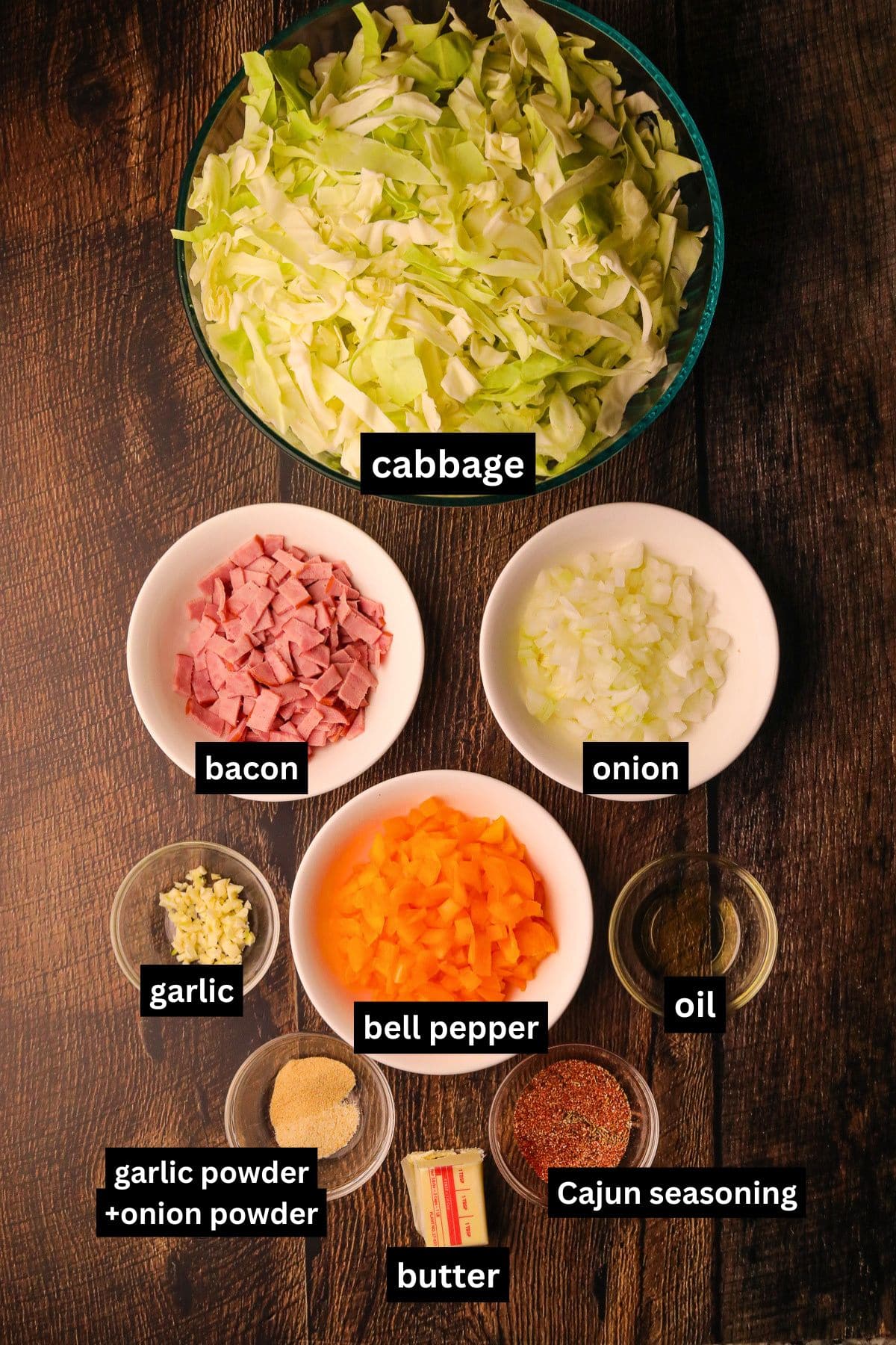 Southern fried cabbage ingredients arranged in bowls on a table top.