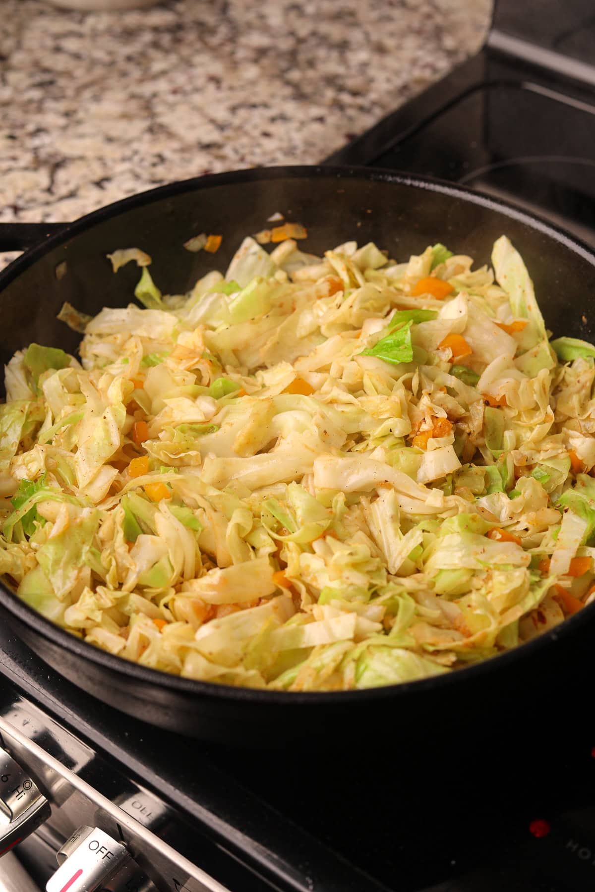 Southern Fried cabbage cooking in a pan on the stove top.