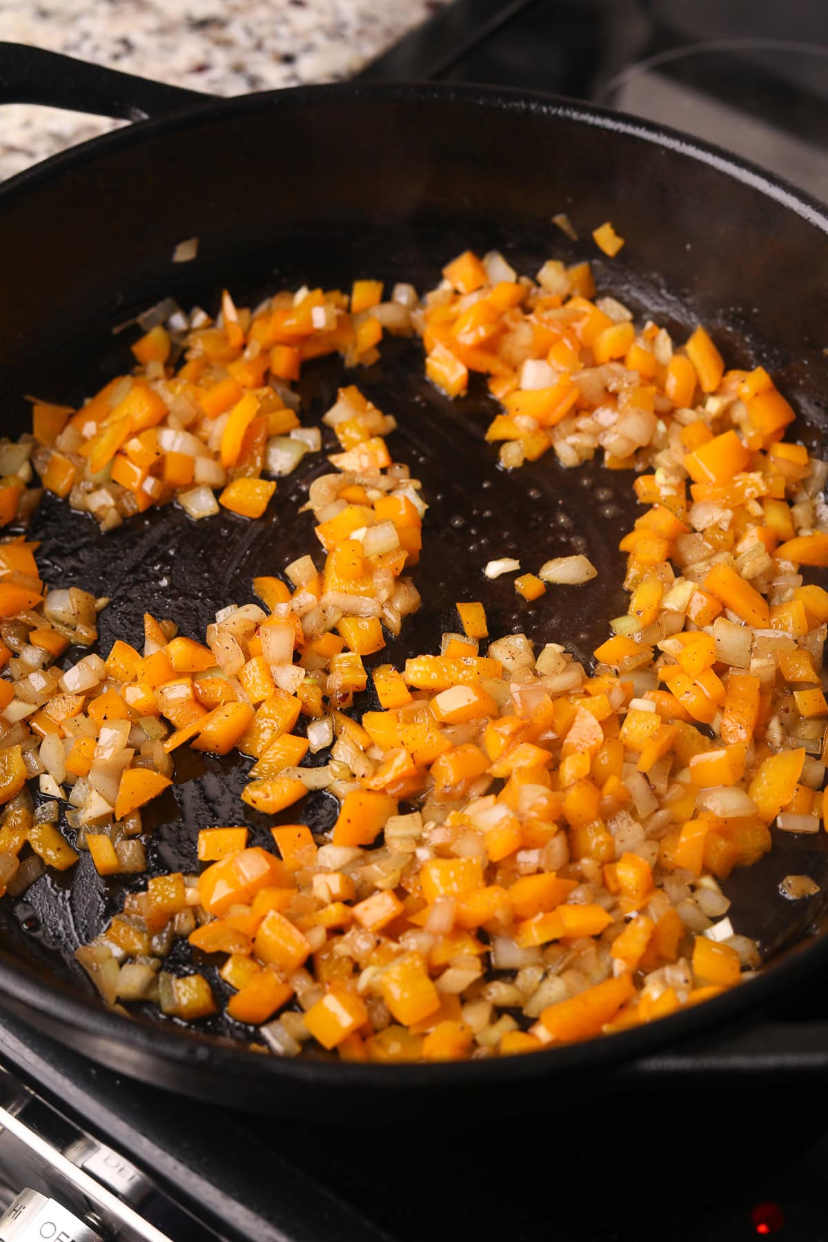 Veggies cooking for southern fried cabbage in a skillet.