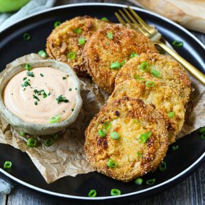 Southern fried green tomatoes on a plate with comeback sauce.