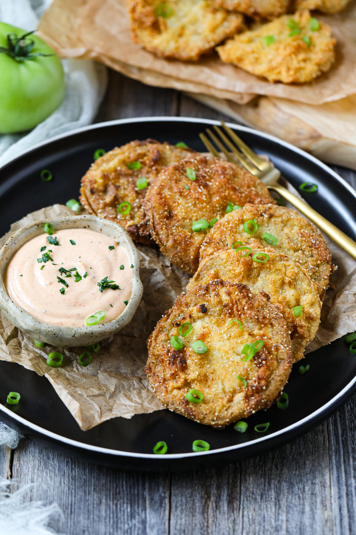 Southern fried green tomatoes on a plate with comeback sauce.