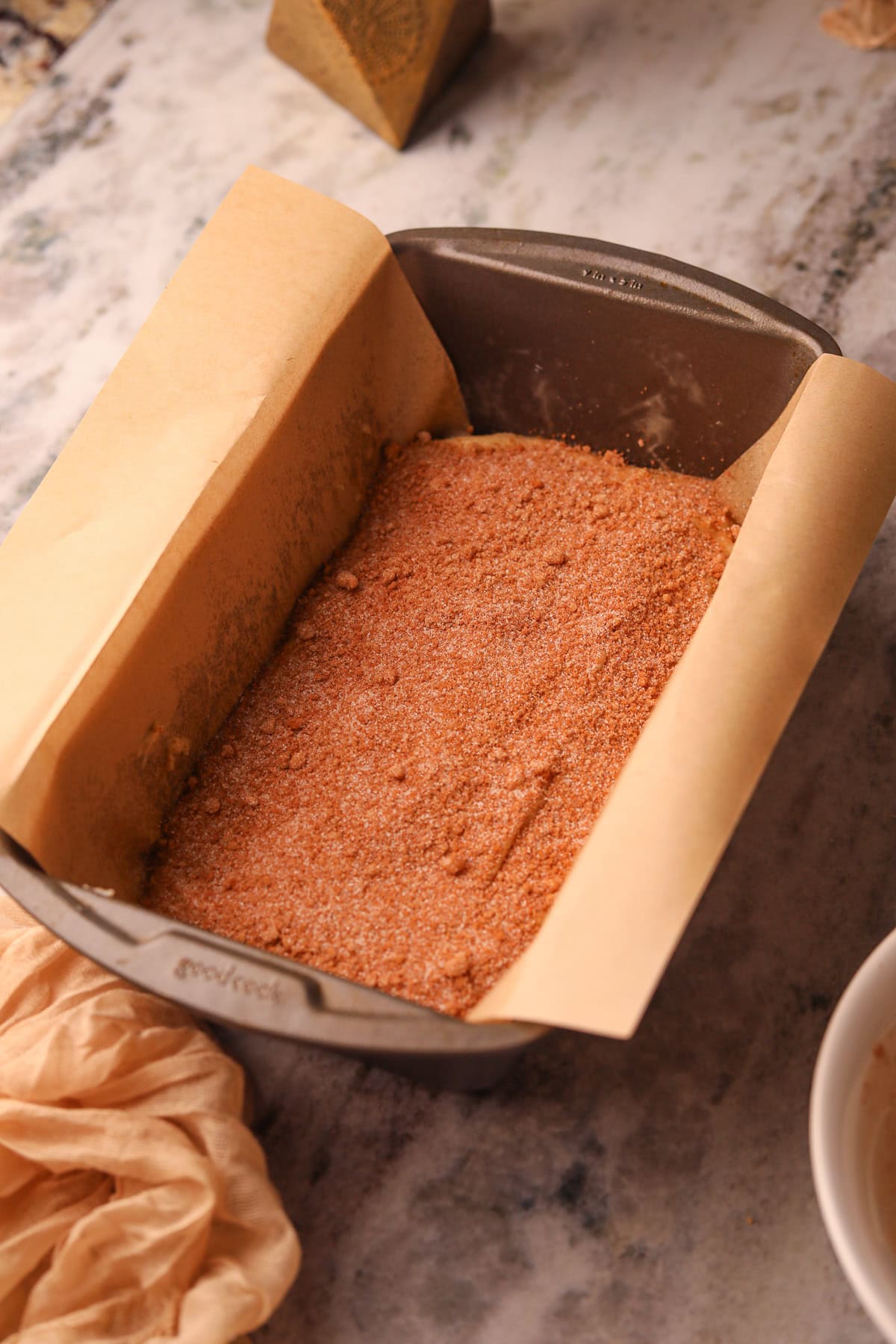 First layer of cinnamon roll quick bread batter in a loaf pan.