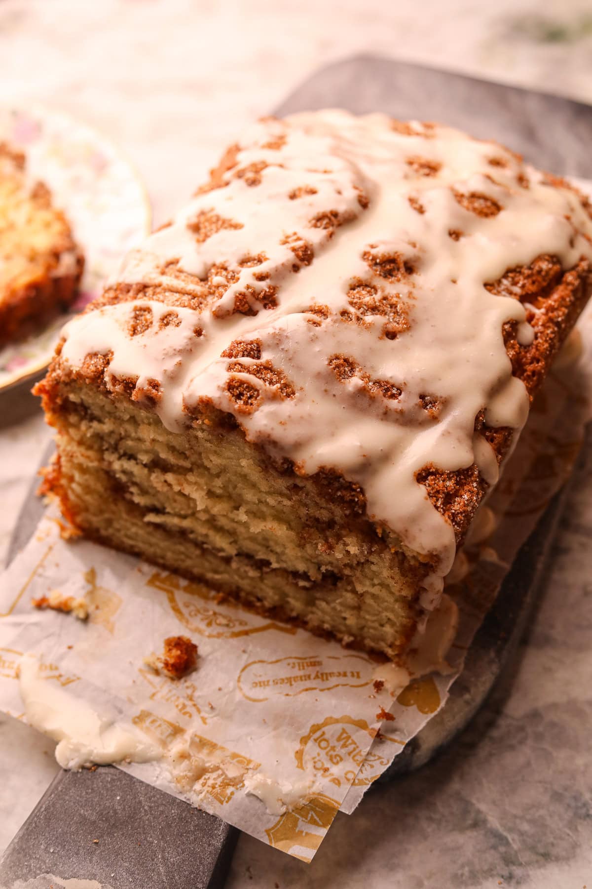 Glazed cinnamon roll quick bread on a serving board.