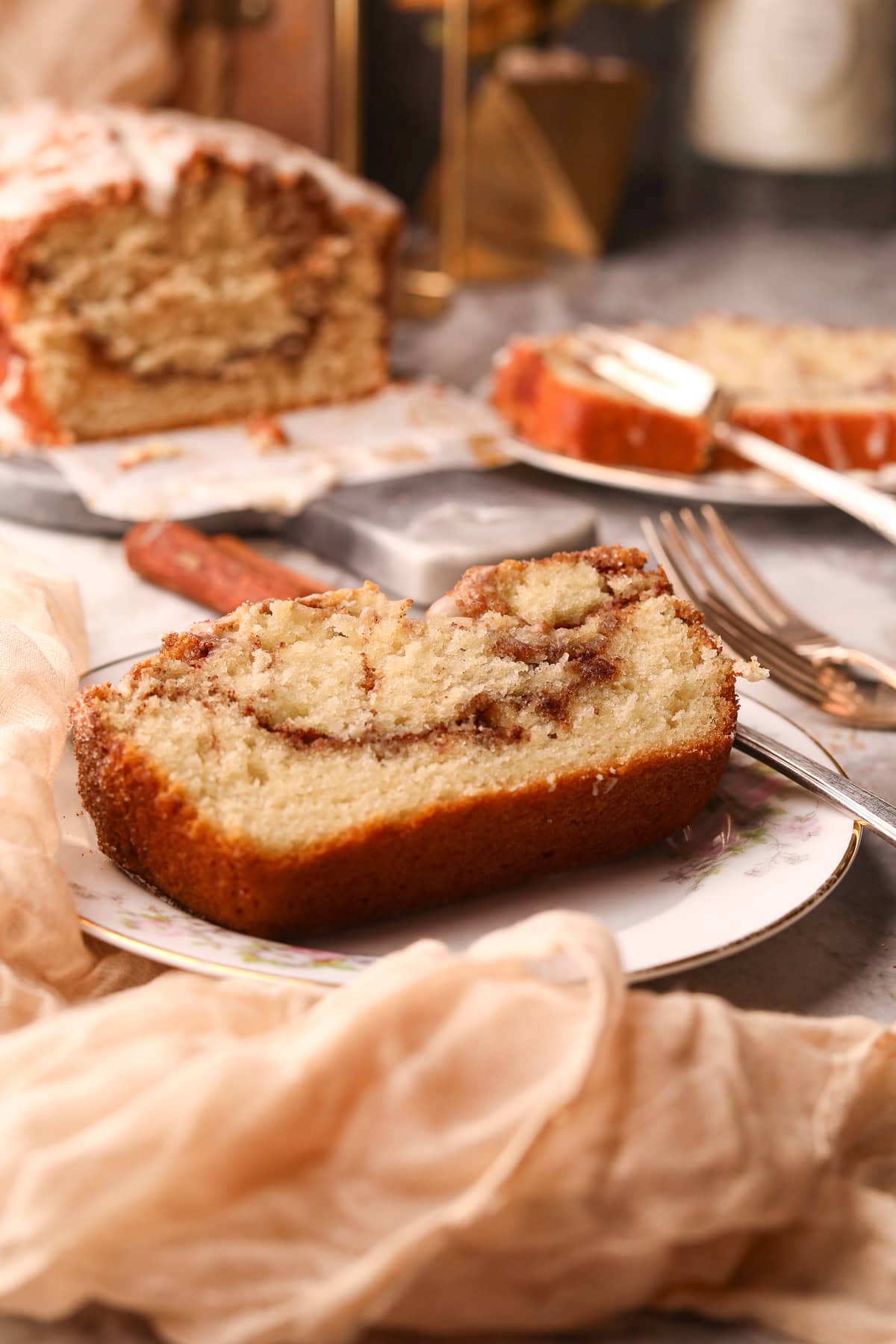 A slice of cinnamon roll quick bread on a dessert plate.